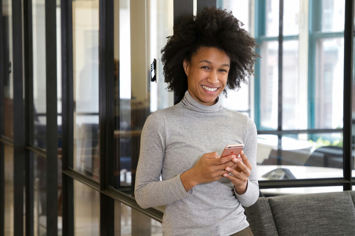 Photo d'une jeune femme qui consulte son téléphone, dans une ville française